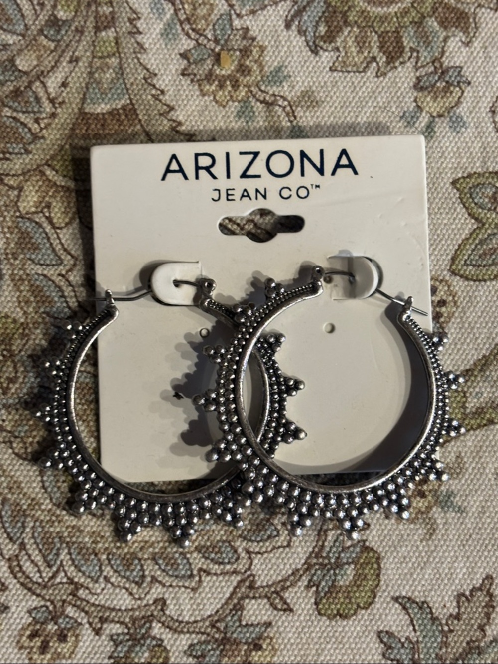 Silver toned medium size decorative hoop earrings